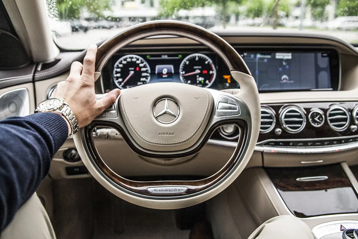 Hand eines Chauffeurs am Lenkrad eines Mercedes-Benz